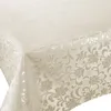 A close-up view of a cream-colored tablecloth with a floral damask pattern. Produktbild-Vorschau