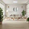 A modern living room with a sofa, chairs, coffee table, and plants. Produktbild-Vorschau