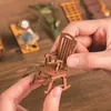 Hands holding a miniature wooden rocking chair. Náhled obrázku produktu