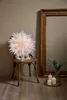 A white paper star decoration is placed on a wooden chair next to a large wooden picture frame. Three white candles are lit on a round tray in front of the frame. Podgląd zdjęcia produktu