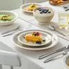 A table setting with plates, bowls, cutlery, and food, suggesting a meal or breakfast. Produktbild-Vorschau