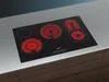 A black induction cooktop with red heating elements is shown on a countertop. Produktbild-Vorschau