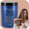 A woman is shown with a large blue hair mask container and is combing her hair. Podgląd zdjęcia produktu