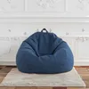 A blue bean bag chair sits on a rug in a room with white decorative molding. Voir les images du produit