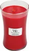 A red candle in a glass jar with a label. Podgląd zdjęcia produktu