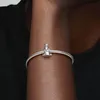 A close-up shot of a person's arm wearing a silver bracelet with a charm. Produktbild-Vorschau