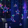 A string of colorful star and moon-shaped LED lights hanging outdoors at night, with a solar panel and remote control visible. Produktbild-Vorschau