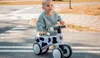 A young child is on a balance bike on a street with crosswalk markings. Náhled obrázku produktu
