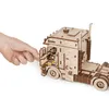 A hand is shown interacting with a wooden model truck. Produktbild-Vorschau