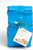 A blue package of biscuits tied with green string, with a tag attached. Produktbild-Vorschau
