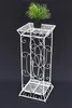 A white metal plant stand with a potted plant on top, set against a black background. Anteprima dell’immagine prodotto