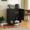 A black sideboard cabinet with its door open, displaying items inside, in a room with wooden floors and a rug. Podgląd zdjęcia produktu