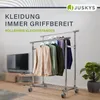 A clothing rack with clothes hanging on it, placed in a room with a television and a plant. Podgląd zdjęcia produktu