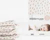 A stack of folded baby blankets with a product package showing a baby. Produktbild-Vorschau