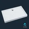 A white rectangular shower tray with a chrome drain is shown against a dark blue background. A blue water droplet icon with text is in the bottom right corner.