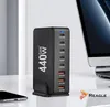 A black multi-port charger is shown on a desk next to a laptop and a smartphone. Anteprima dell’immagine prodotto