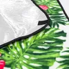 A close-up view of a blanket with a tropical leaf and flower pattern, showing water droplets on the surface and the insulating backing. Náhled obrázku produktu