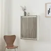 A wall-mounted folding table is shown in a room with a chair and artwork. Podgląd zdjęcia produktu