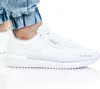 A close-up shot of a person wearing white Puma sneakers. Anteprima dell’immagine prodotto