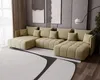 A modern living room with a large U-shaped sofa, abstract art on the wall, and a floor lamp.