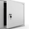 A white metal cabinet with a key in the lock of one of its doors, which is slightly ajar. Produktbild-Vorschau