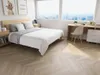 A bedroom with a bed, desk, and window overlooking a city. Produktbild-Vorschau