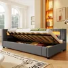 A bedroom scene with a grey upholstered bed frame open to reveal storage space underneath. The bed has LED lighting integrated into the headboard. Anteprima dell’immagine prodotto