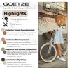A woman stands next to a bicycle in front of a mosaic wall. Produktbild-Vorschau