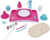 A pottery craft kit for children, including a pink pottery wheel, tools, paints, and clay discs, arranged on a white background. Produktbild-Vorschau