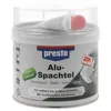 A white tub of Presto 2K Alu Spachtel with a clear plastic lid, showing a small tube of hardener inside. Náhľad obrázku produktu