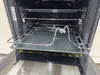 An open oven with a baking tray and rack extended. Produktbild-Vorschau