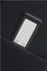 A close-up of a luggage tag with fields for name, address, phone, and email, partially tucked into a black fabric pocket. Produktbild-Vorschau