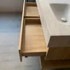 A close-up view of an open wooden drawer of a bathroom vanity with a sink on top. Anteprima dell’immagine prodotto