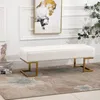 A white bench with gold legs sits on a rug in a room with artwork on the wall. Náhľad obrázku produktu