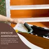 A person is painting a piece of furniture with a roller, applying black chalk paint. Produktbild-Vorschau