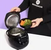 A person is holding a bowl of steamed vegetables over an open rice cooker with rice inside. Anteprima dell’immagine prodotto