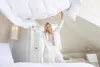 A woman is making a bed in a bedroom. Produktbild-Vorschau