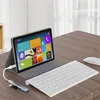 A tablet, keyboard, and USB hub are set up on a wooden desk, suggesting a workspace. Produktbild-Vorschau