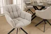 A dining chair with a bouclé fabric in a light beige/greige color is shown in a dining room setting, with a dining table and other chairs visible in the background. Produktbild-Vorschau