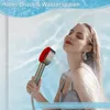 A woman is holding a showerhead and water is spraying from it. The background appears to be a tiled shower wall with water effects. Produktbild-Vorschau