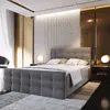 A bedroom scene featuring a large upholstered bed. Produktbild-Vorschau