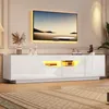 A modern white TV stand with LED lighting, featuring a large flat-screen TV mounted above it. Produktbild-Vorschau
