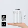 A hand holding a glass jar with dimensions and weight indicated. Voir les images du produit
