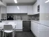 A clean, modern kitchen with white high-gloss cabinets and a white table and chairs. Produktbild-Vorschau