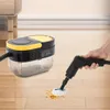 A hand is using a black and yellow steam cleaner to clean a spill on a wooden floor, with the steam cleaner unit in the background. Náhled obrázku produktu