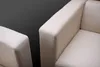 Close-up of two modern, cream-colored leather armchairs against a dark gray background. Produktbild-Vorschau
