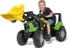 A young boy is sitting on a green toy tractor with a yellow front loader. Produktbild-Vorschau