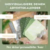 A flat lay of items for creating a personalized advent calendar, including paper bags, stickers, and wooden clips, arranged on a wooden surface with scattered faux snow and pine branches. Anteprima dell’immagine prodotto