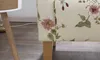 A close-up view of the floral patterned upholstery of a sofa, with a wooden leg visible. Produktbild-Vorschau