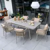 An outdoor patio setting with a dining table and chairs. Produktbild-Vorschau